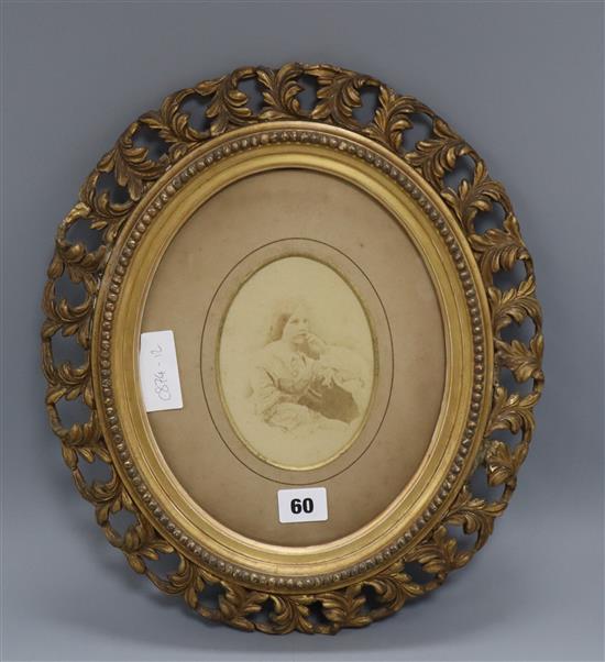 An oval pierced gilt frame with photographic portrait